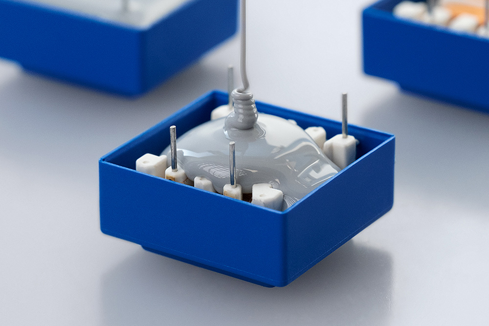 Electronic component being filled with Wevo potting compound.